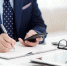 Cropped image of businessman checking messages in smartphone and taking notes in planner - Газета Магаданская правда