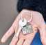 Young woman holding key of new home at street - Газета Магаданская правда